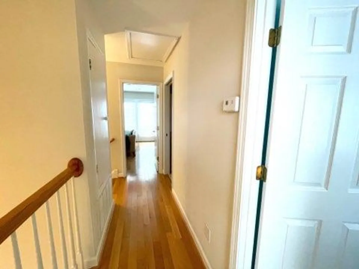 The photo depicts a hallway with doors and a handrail, inviting viewers to imagine moving through the home as they prepare for or return from their adventures. The perspective leads naturally toward an unseen destination, evoking a sense of exploration and transition.